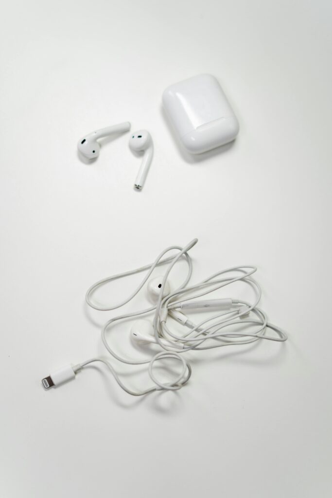 Overhead view of wireless and wired earbuds on a white background, showcasing modern audio technology.